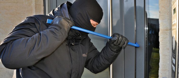 Man trying to break into a residential home using a crowbar